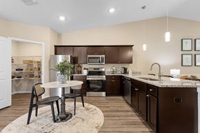 Bennington apartment for rent - A kitchen with brown cabinets and a white table.