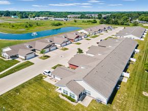 Brownsburg apartment for rent - A large building with a grey roof is surrounded by smaller buildings and a body of water.