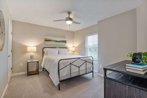 Brownsburg apartment for rent - A bedroom with a bed, nightstands, and a ceiling fan.