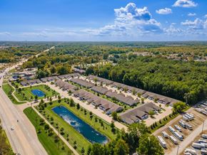 Brownstown apartment for rent - A bird's eye view of a residential area with houses, a swimming pool, and a parking lot.