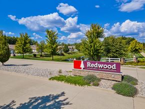 Brownstown apartment for rent - A sign for Redwood Apartments is in front of a grassy area.