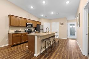 Brownstown apartment for rent - A kitchen with wooden cabinets and a white island.