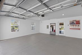 Brownstown apartment for rent - A spacious room with a white ceiling and walls, a window with blinds, and a few posters on the wall.