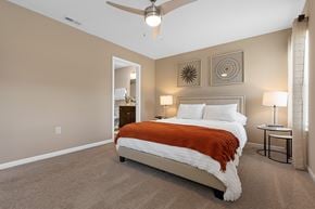 Burlington apartment for rent - A bedroom with a bed, two lamps, and a ceiling fan.