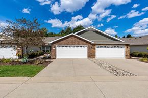 Canton apartment for rent - A house with a white garage door is in front of a tree.