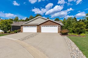 Canton apartment for rent - A house with a white garage door is surrounded by a gravel driveway and a grassy lawn.