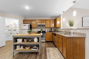 Dayton apartment for rent - A kitchen with wooden cabinets and a grey island.