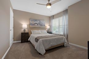 Dayton apartment for rent - A bedroom with a large bed and a painting on the wall.