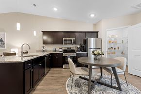 Chesterfield apartment for rent - A modern kitchen with dark brown cabinets and a round table with a vase of flowers on it.
