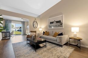 Chesterfield apartment for rent - A living room with a white couch, a coffee table, and a painting on the wall.
