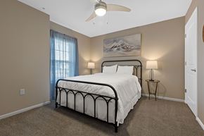 Chesterfield apartment for rent - A bedroom with a bed, two lamps, and a painting on the wall.