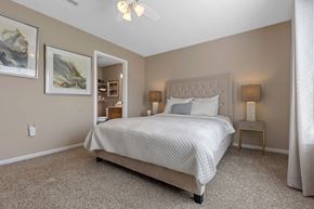 Commerce Twp apartment for rent - A bedroom with a large bed and a ceiling fan.