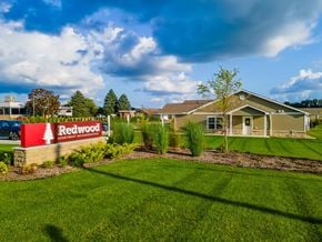 Kalamazoo apartment for rent - A sign for Redwood Apartment Homes is in front of a building.