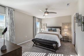 Kalamazoo apartment for rent - A bedroom with a large bed and a ceiling fan.