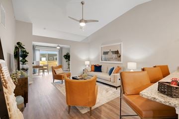 Crystal Lake apartment for rent - A living room with a white couch and orange chairs.