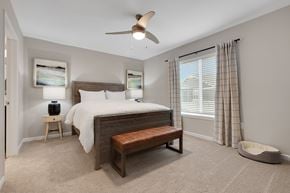 Crystal Lake apartment for rent - A bedroom with a bed, bench, and a ceiling fan.
