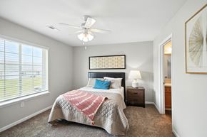 Danville apartment for rent - A bedroom with a bed, a ceiling fan, and a window with blinds.