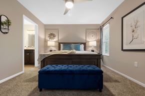 Dewitt apartment for rent - A bedroom with a bed, a bench, and a ceiling fan.