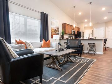 Delaware apartment for rent - A modern living room with a black leather couch and a coffee table.