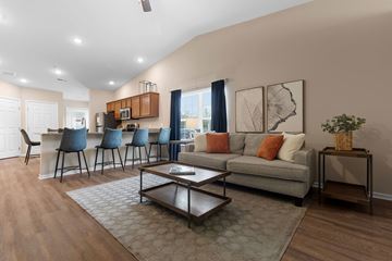 Lansing apartment for rent - A living room with a grey couch and a coffee table.