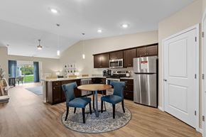 Lansing apartment for rent - A modern kitchen with a table and chairs in the middle.