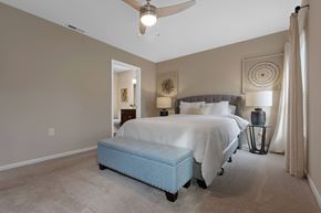 Lansing apartment for rent - A bedroom with a bed and a ceiling fan.
