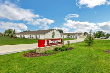 Fairborn apartment for rent - A sign for Redwood Assisted Living is in front of a building.