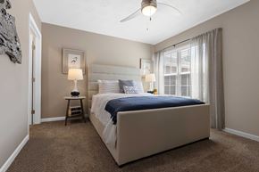 Fairborn apartment for rent - A bedroom with a large bed and a ceiling fan.