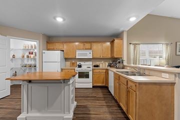 Fort Wayne apartment for rent - A kitchen with wooden cabinets and a white refrigerator.
