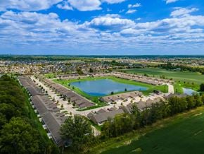Fort Wayne apartment for rent - A bird's eye view of a residential area with a large swimming pool and a green field.