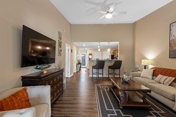 Fort Wayne apartment for rent - A living room with a white couch and a television on the wall.