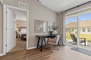 Galloway apartment for rent - A room with a desk and chairs with a view of a building outside.