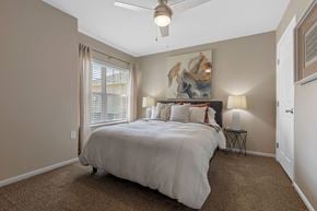 Grand Blanc Township apartment for rent - A bedroom with a large bed and a ceiling fan.