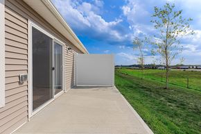 Greenfield apartment for rent - A house with a sliding glass door and a concrete walkway leading to it.