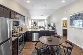 Greenwood apartment for rent - A modern kitchen with dark wood cabinets and stainless steel appliances.