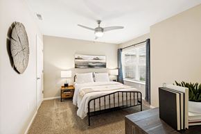 Greenwood apartment for rent - A bedroom with a bed, nightstands, and a ceiling fan.