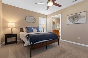 Greer apartment for rent - A bedroom with a bed, nightstand, and a ceiling fan.
