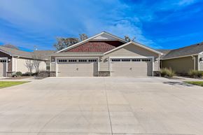 Greer apartment for rent - A two-car garage with a red roof is surrounded by a concrete driveway and other houses.