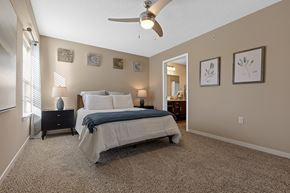 Grimes apartment for rent - A bedroom with a bed, nightstand, and a ceiling fan.
