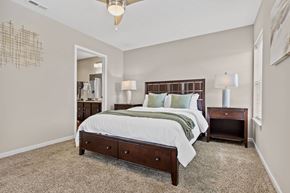 Grove City apartment for rent - A bedroom with a large bed and a chandelier.