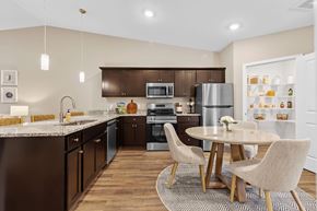 Groveport apartment for rent - A modern kitchen with dark brown cabinets and a white island.