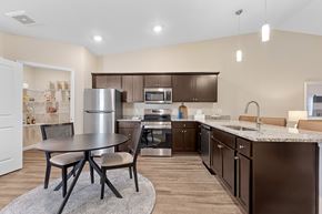 Hickory apartment for rent - A kitchen with brown cabinets and a table with four chairs.