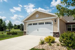 Johnstown apartment for rent - A two-car garage with a white door is situated in front of a house.