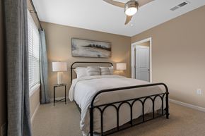 Kannapolis apartment for rent - A bedroom with a large bed and a ceiling fan.