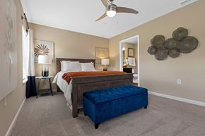 Lafayette apartment for rent - A bedroom with a bed, nightstand, and a ceiling fan.