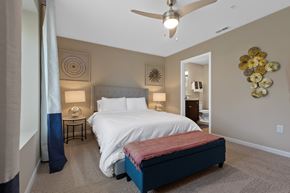 Lockport apartment for rent - A bedroom with a bed, nightstand, and a ceiling fan.
