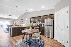 Louisville apartment for rent - A modern kitchen with a round wooden table and a stainless steel refrigerator.