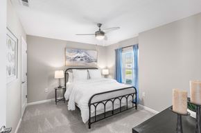 Louisville apartment for rent - A bedroom with a large bed and a painting on the wall.