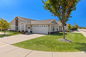 Macomb apartment for rent - A house with a garage and a tree in front.