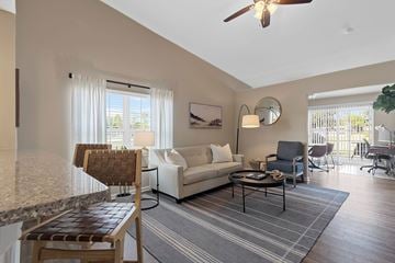 Macomb apartment for rent - A living room with a white couch and a wooden chair.